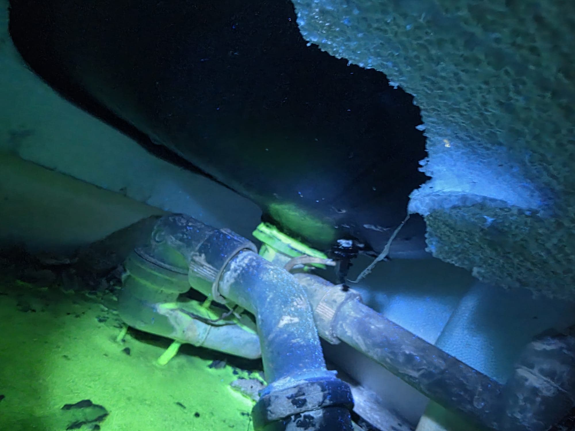 Leckageortung mit UV-Prüfmittel: Das fluoreszierende Prüfmittel markiert die undichte Stelle am Rohranschluss